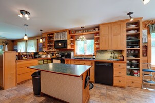Una cocina amplia con armarios de madera, una isla central y lavavajillas.
