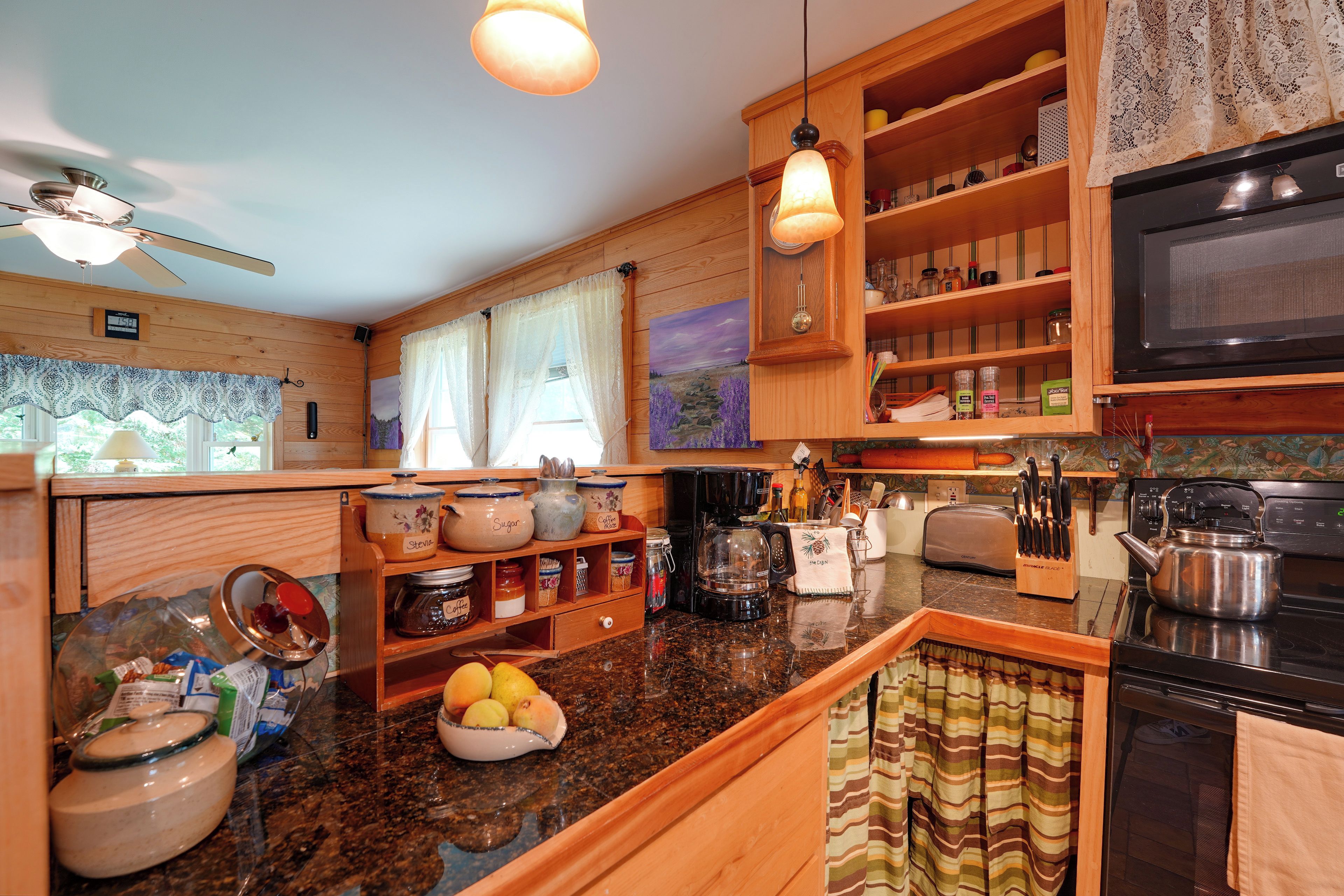 A kitchen with wooden cabinets, a microwave, a coffee maker, and various kitchen utensils.