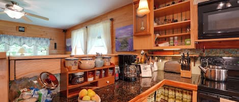 A kitchen with wooden cabinets, a microwave, a coffee maker, and various kitchen utensils.