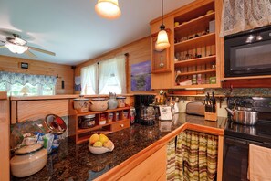A kitchen with wooden cabinets, a microwave, a coffee maker, and various kitchen utensils.