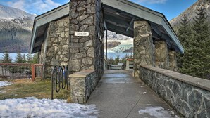 A stone pavilion labeled "PAVILION" with a metal roof, surrounded by snow-covered ground and mountains in the background. - Expansive Getaway ~ 2 Miles to Mendenhall Glacier! (Juneau)