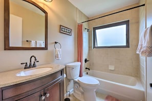 Une salle de bain avec un lavabo, des toilettes et une baignoire.