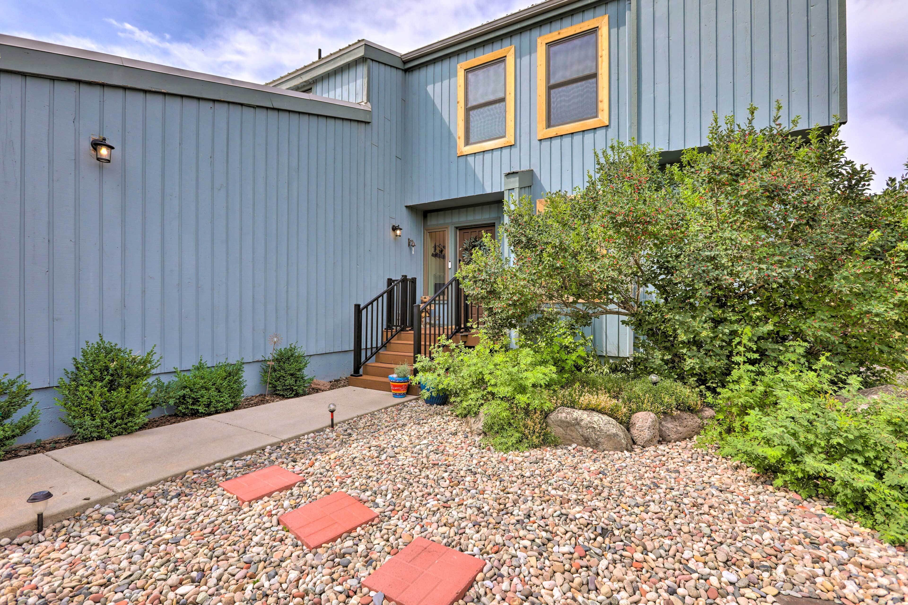 A two-story building with a blue exterior, a front door, and a small porch with steps.