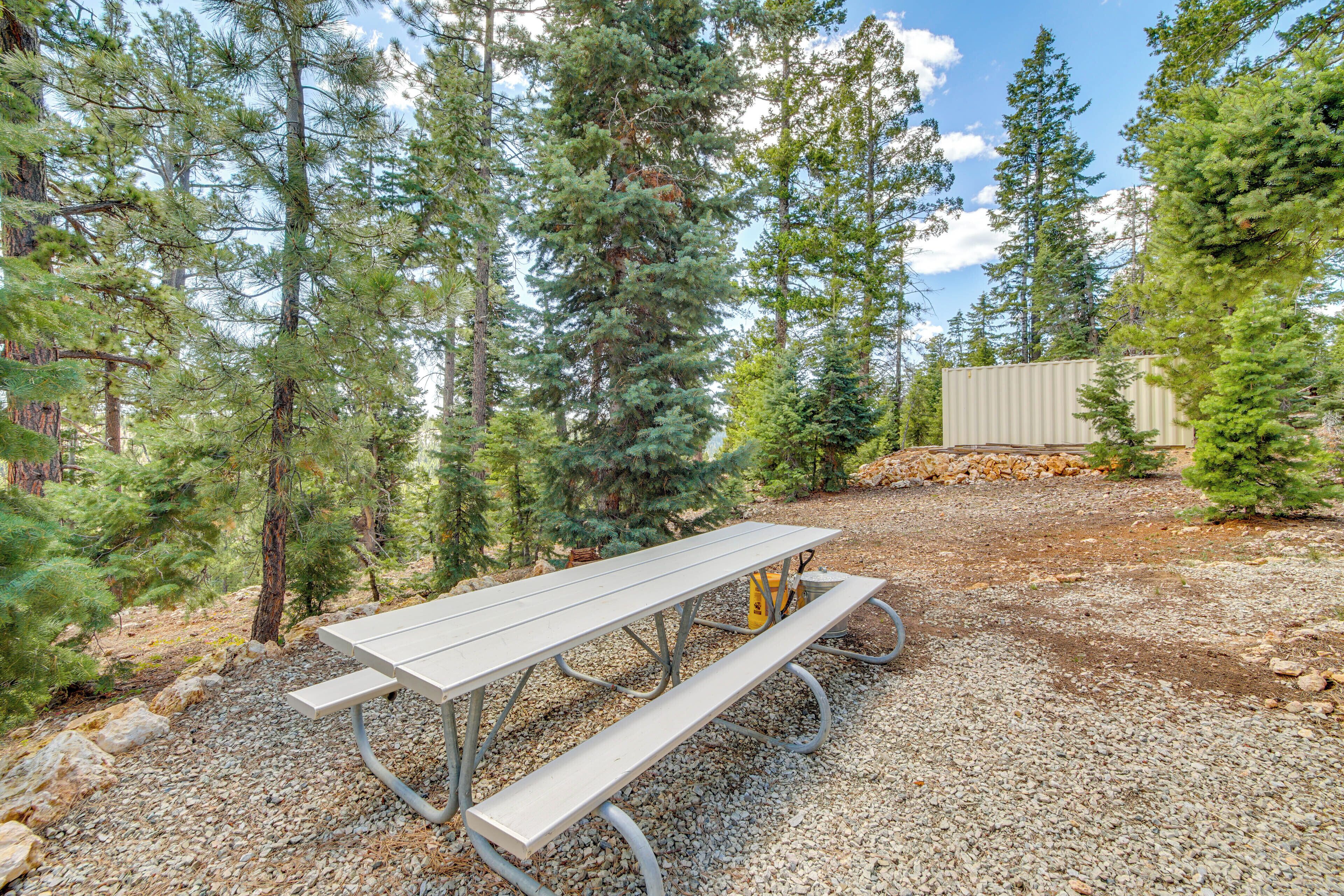 A picnic table in a forested area with a gravel ground.