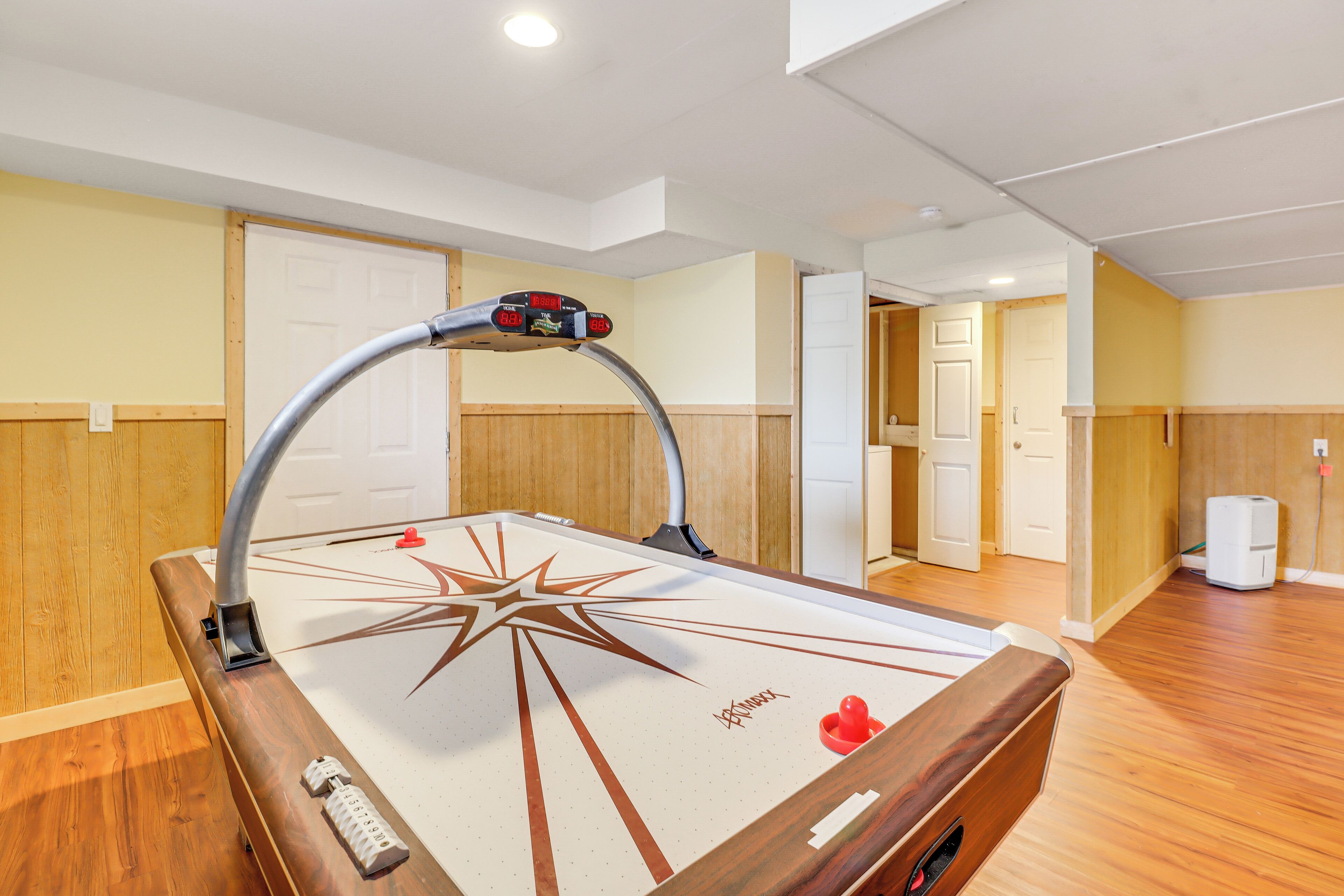 A pool table with a star design, a mounted cue, and a red ball.