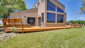 A modern two-story house with a large deck, outdoor seating, and a clear view of the surrounding landscape. - 'mesa View House' w/ Hot Tub: Walk to Winery! (Palisade)
