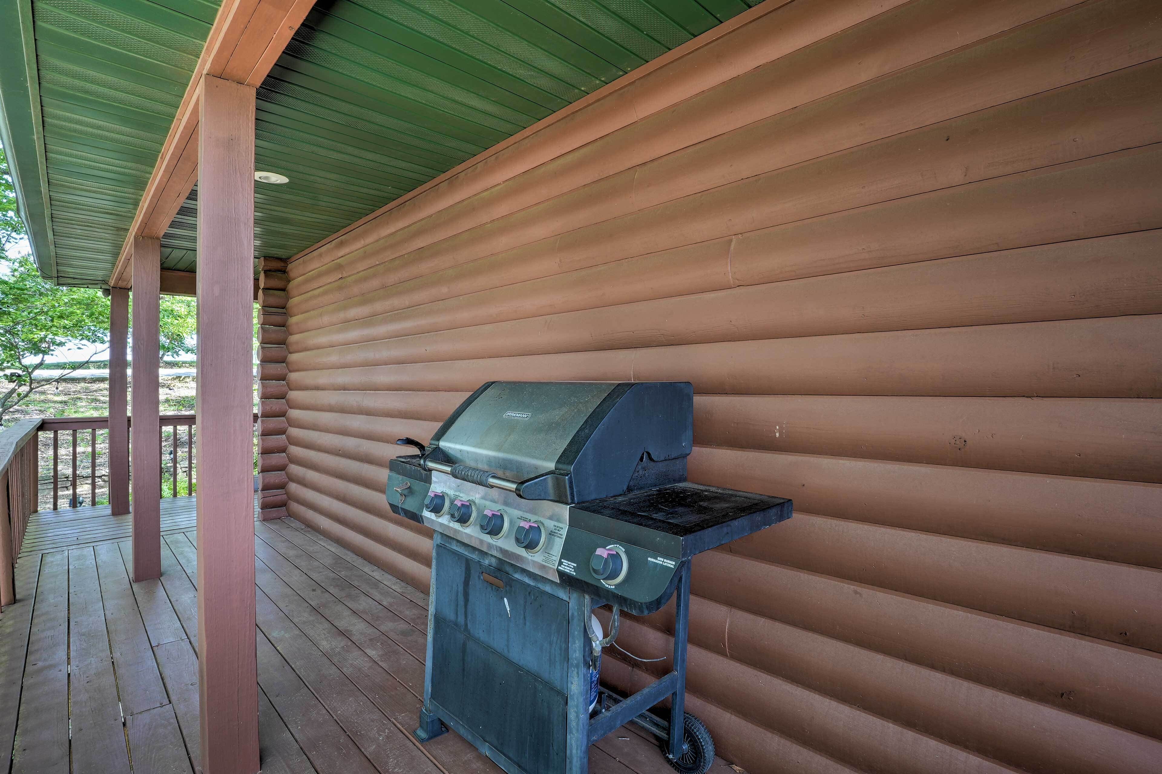 A covered outdoor area with a wooden deck, a grill, and a green roof.