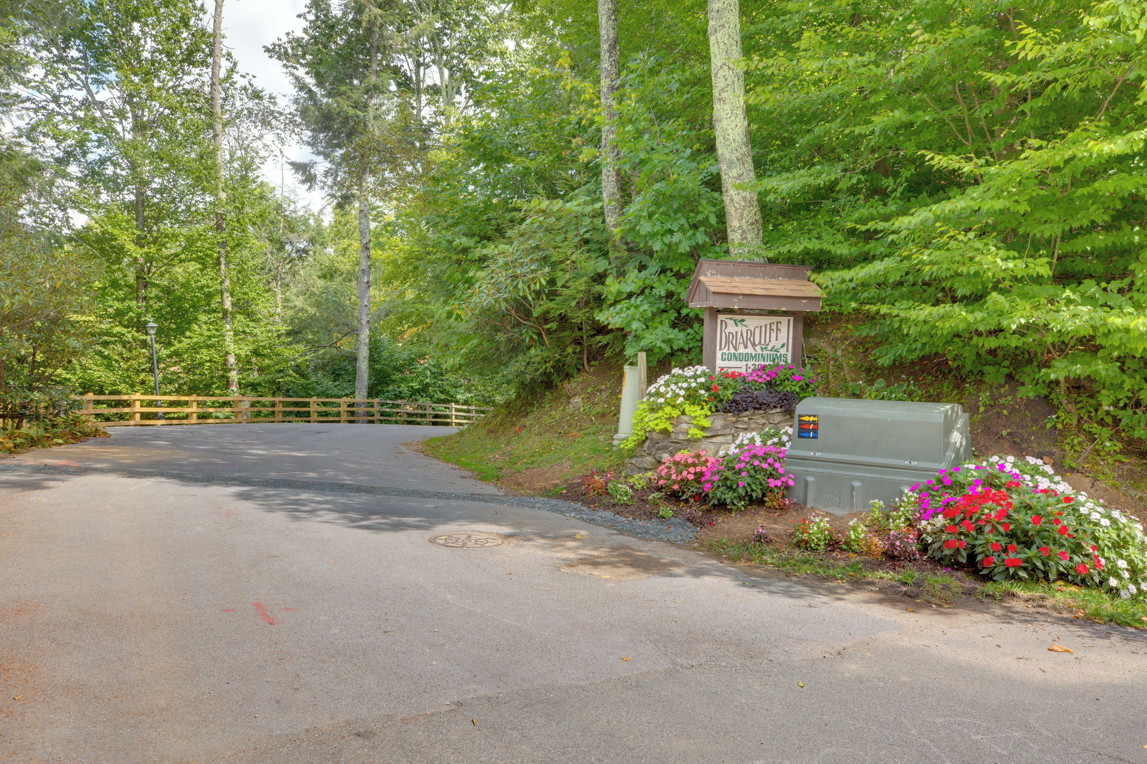 A road leading to a gated entrance with a sign for Briarcliffe Condominium.