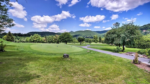A golf course with a winding path, lush green grass, and trees.