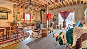 A cozy living room with wooden furniture, a rocking chair, a crochet blanket, and a stone wall.