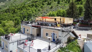 A rooftop bar with outdoor seating, a covered area, and a view of a hillside. - Modern Lava Hot Springs Studio, Walk to Pools (Lava Hot Springs)