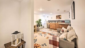 A cozy living room with a floral rug, a grey sofa with cushions, and a small table with a lantern. - Island Park Couple's Escape ~ 1 Mi to Beach! (Island Park)