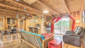 Ein Holzinterieur mit einer Couch, einem Massagesessel, einem Essbereich und einer Küche.