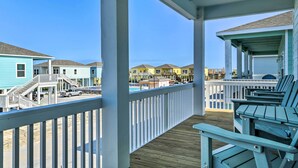 A wooden deck with a railing, a pool, and beach houses in the background. - 6 Mi to Beach: Rockport Home w/ Pool Access! (Rockport)