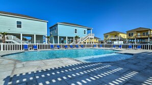 A swimming pool area with a white fence, blue and yellow buildings, and a clear blue sky. - 6 Mi to Beach: Rockport Home w/ Pool Access! (Rockport)