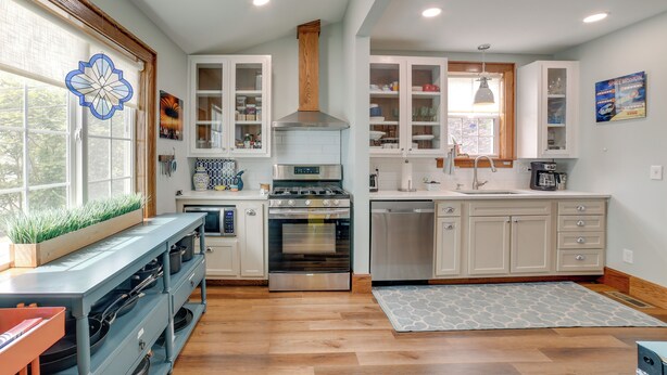 A modern kitchen with built-in appliances, a wooden ceiling vent, and a window with a decorative view. - Pet-friendly Murph Landing - 1 Mile to Wvu! (Morgantown)