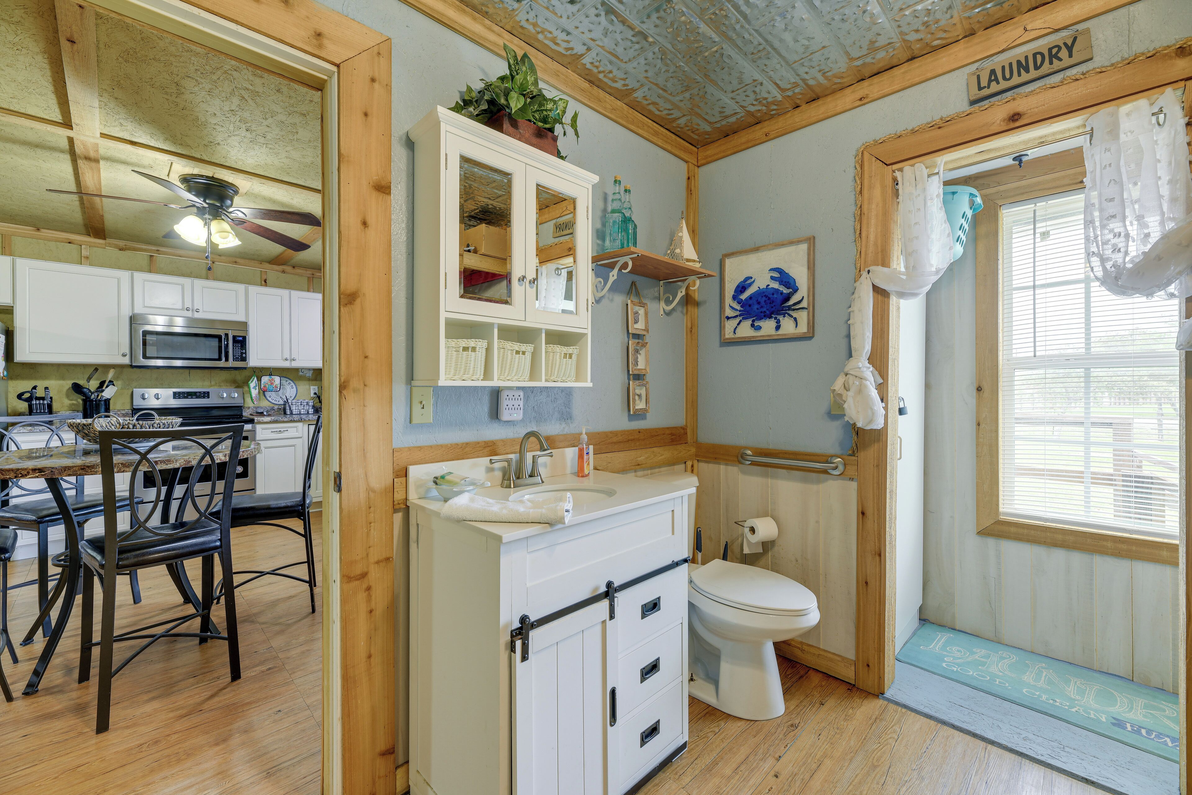 A compact kitchen with a microwave, sink, and dining area.
