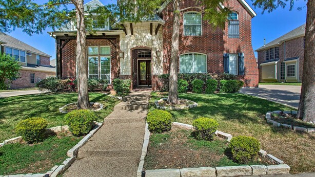 A two-story brick house with a stone entrance, a front yard with a pathway, and a small garden. - Private Pool & Hot Tub: Spacious Murphy Getaway (Plano)
