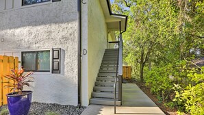 Een modern huis met twee verdiepingen en een betonnen trap die naar de bovenverdieping leidt.