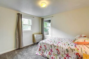 A bedroom with a bed, a dresser, and two windows. - Charming Eugene Vacation Rental - 3 Mi to Downtown (Eugene)