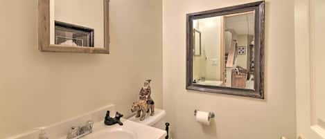 Ein Badezimmer mit Waschbecken, Toilette und zwei Spiegeln.
