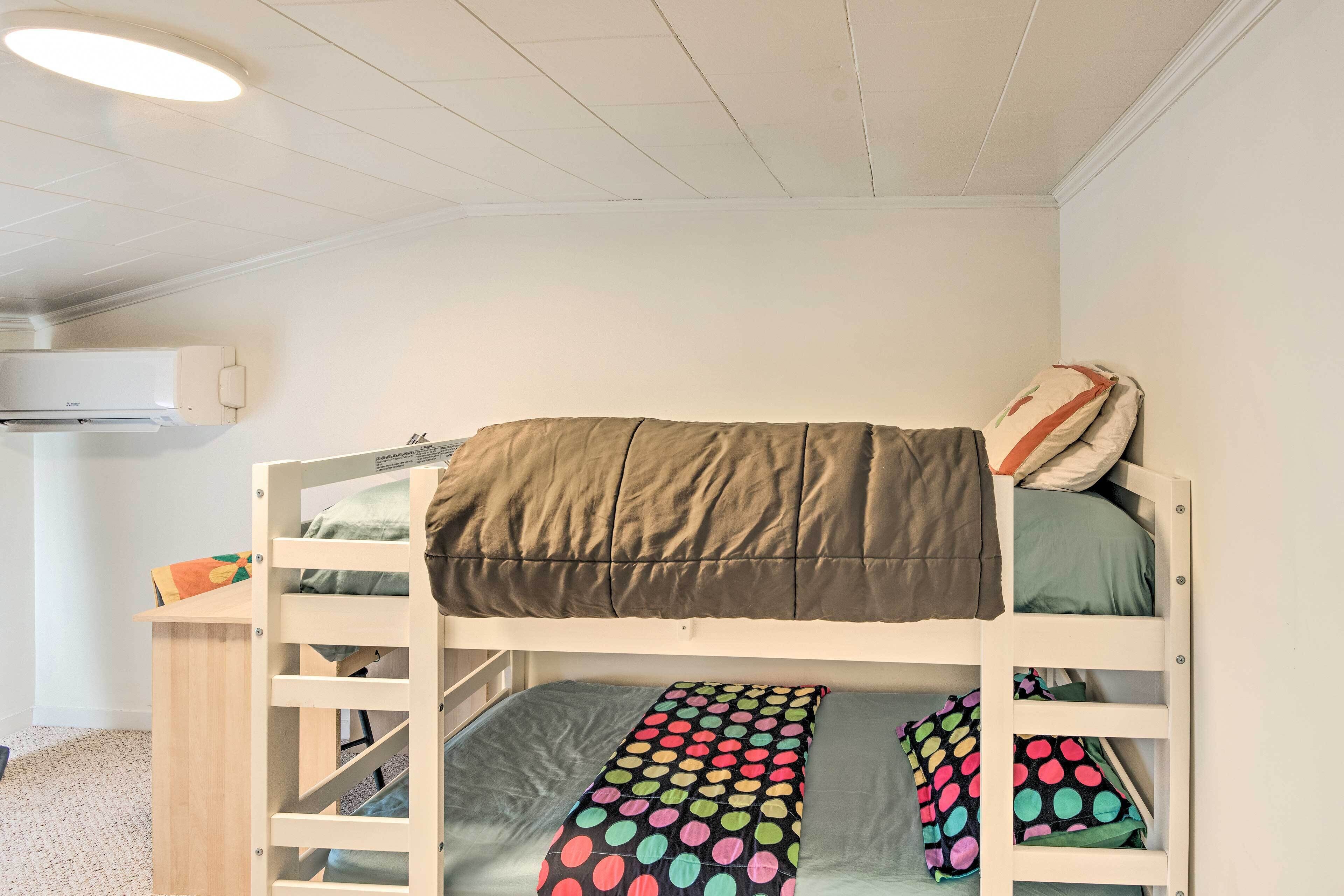 Un lit superposé avec un oreiller à pois et un oreiller à rayures.