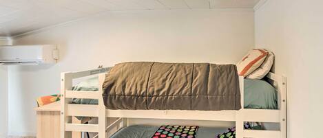 Un lit superposé avec un oreiller à pois et un oreiller à rayures.