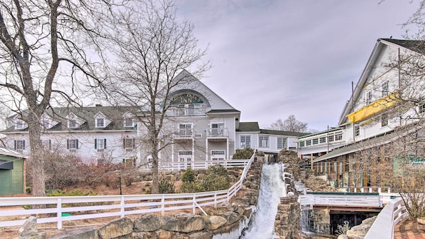 A hotel with a waterfall, stone walls, and a white fence. - Historic Meredith Home: Walk to Town Center! (Meredith)