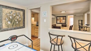 A hockey rink with a control panel, a dining area with bar stools, and a kitchen in the background. - Historic Meredith Home: Walk to Town Center! (Meredith)