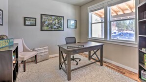 A home office with a desk, chair, framed pictures, and a bookshelf. - Modern Bend Home ~ 3 Mi to Old Mill District! (Bend)