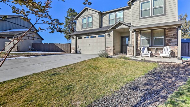 A two-story house with a garage, a covered porch with Adirondack chairs, and a well-maintained lawn. - Modern Bend Home ~ 3 Mi to Old Mill District! (Bend)