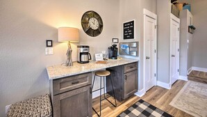 A compact kitchen with a countertop, a coffee maker, a clock, and a welcome sign. - Woodland Park Escape: Licensed, Hot Tub, Mtn Views (Woodland Park)