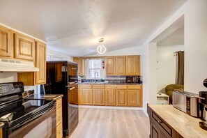 Una cocina moderna con armarios de madera, electrodomésticos de acero inoxidable y una isla central.