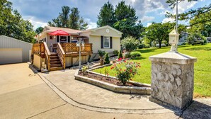 A single-story mobile home with a front deck and a small garden area. - Bull Shoals Lake Home at Beaver Creek Marina! (Kissee Mills)