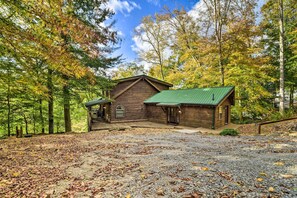 Escape to a serene forest retreat with a cabin-style building surrounded by lush trees and vibrant foliage.