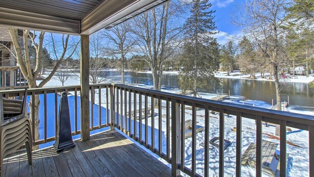 A wooden deck with a view of a lake and trees. - Riverfront Crivitz Condo w/ Fireplace & Views (Crivitz)