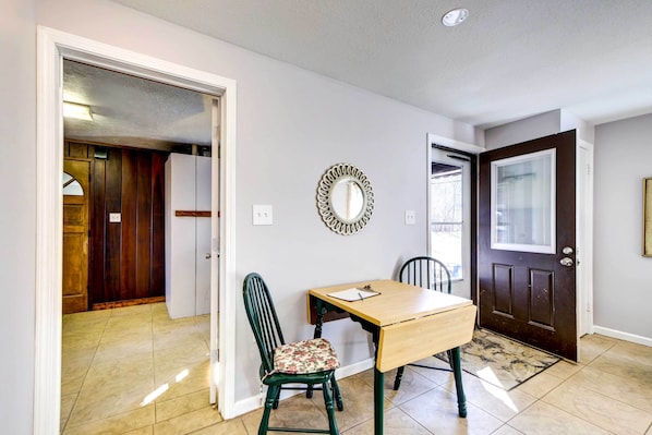 A hallway with a wooden door, a mirror, a small table with a chair, and a tiled floor. - Pet-friendly Youngstown Cottage w/ Yard (Poland)