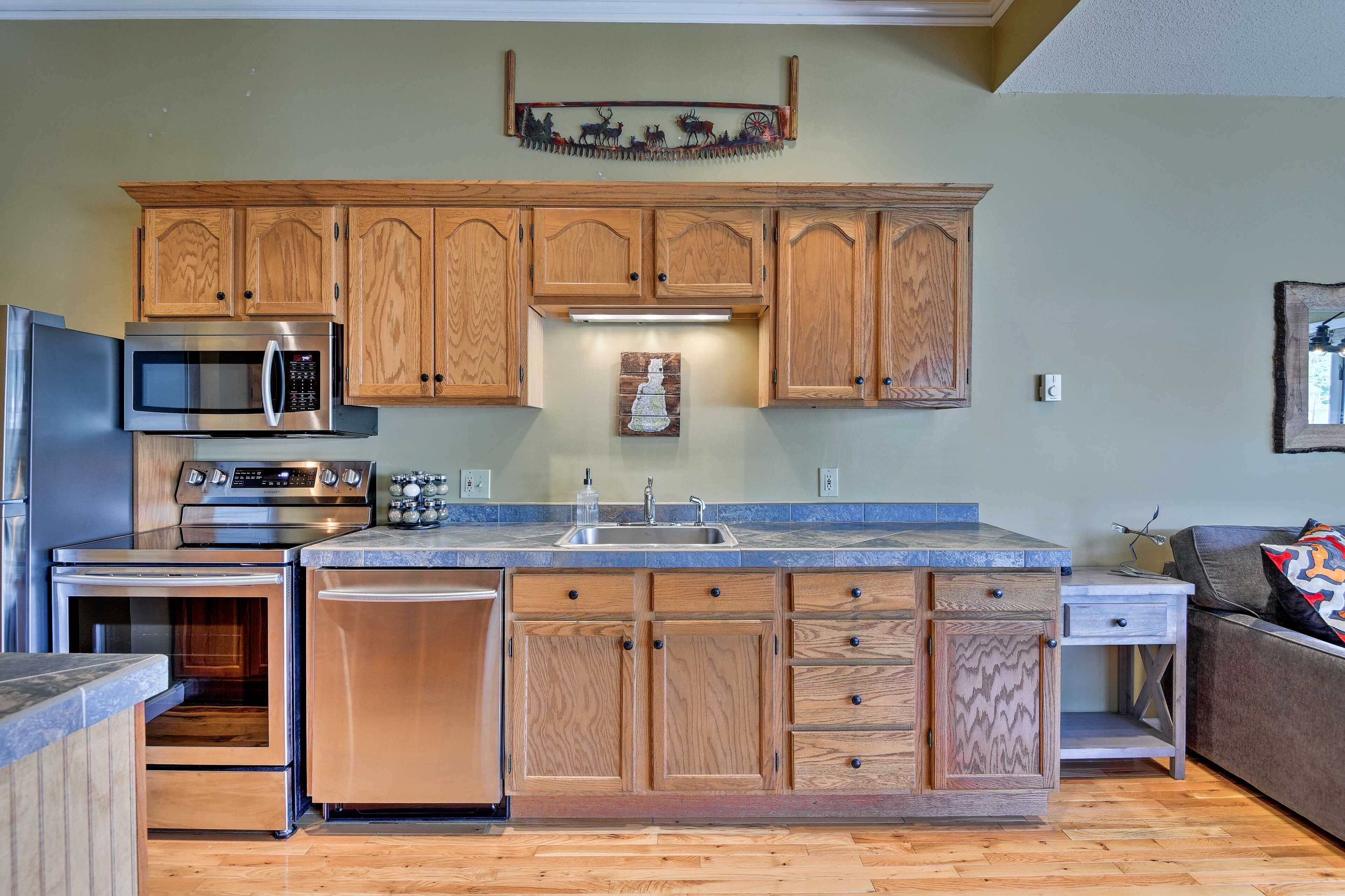 A kitchen with wooden cabinets, stainless steel appliances, a built-in oven, and a dishwasher.