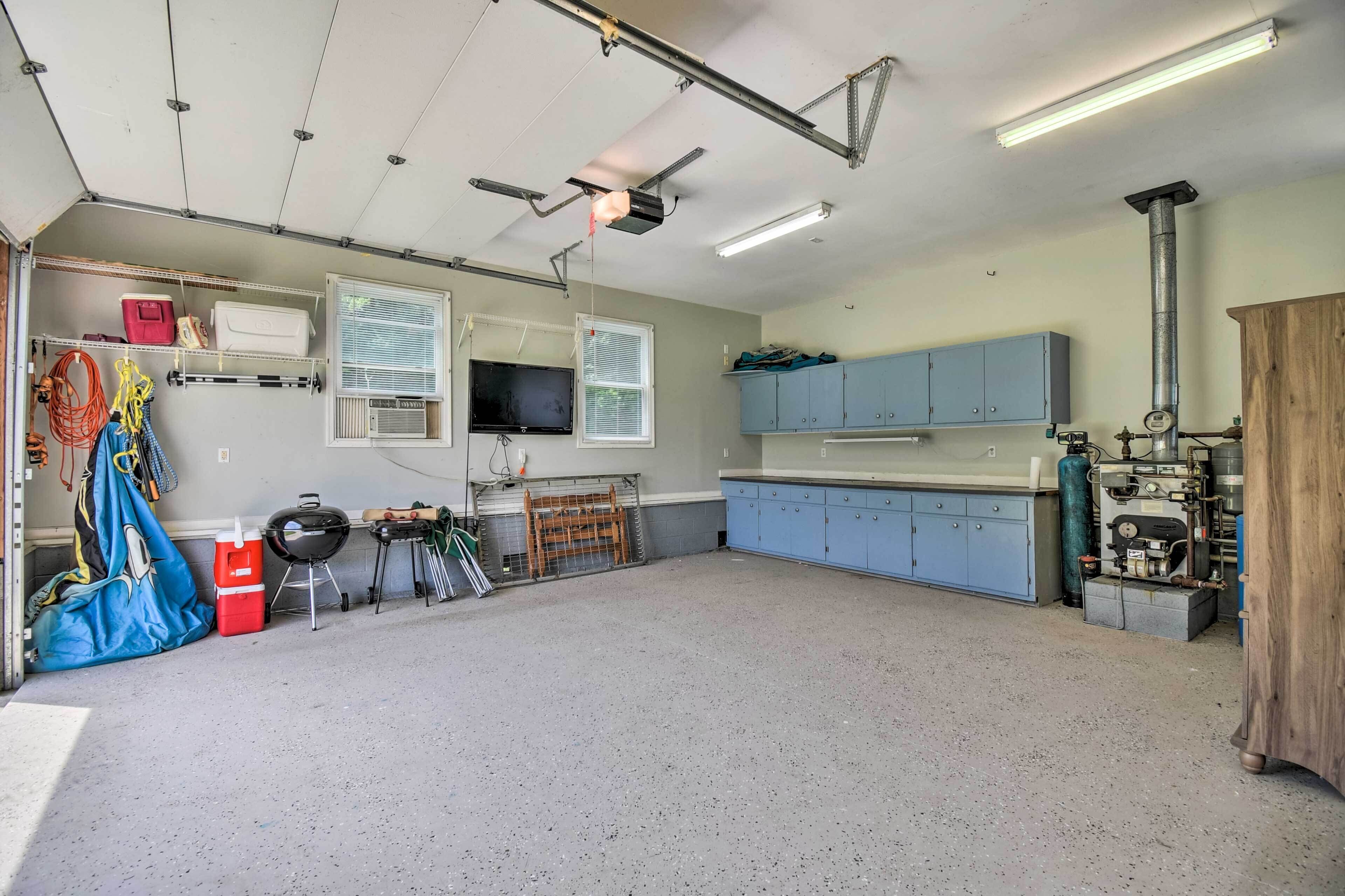 A garage with a workbench, tools, and a television.