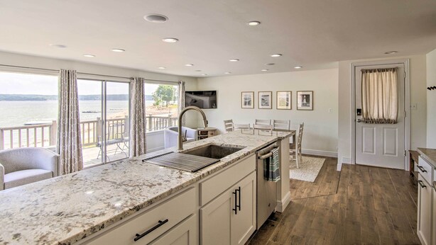 A modern kitchen with a large island, a sink, and a dining area with chairs. - Walk to Boat Ramp! Lakefront Home w/ Deck in Afton (Afton)