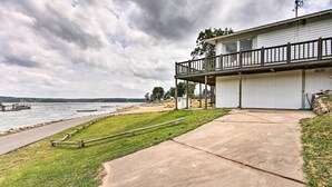 A waterfront property with a concrete deck, a wooden fence, and a building with a balcony. - Walk to Boat Ramp! Lakefront Home w/ Deck in Afton (Afton)