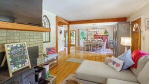 A living room with a fireplace, a television, and a cozy seating area. - Fire Pit & Game Room: Family Home in Marshall! (Weaverville)