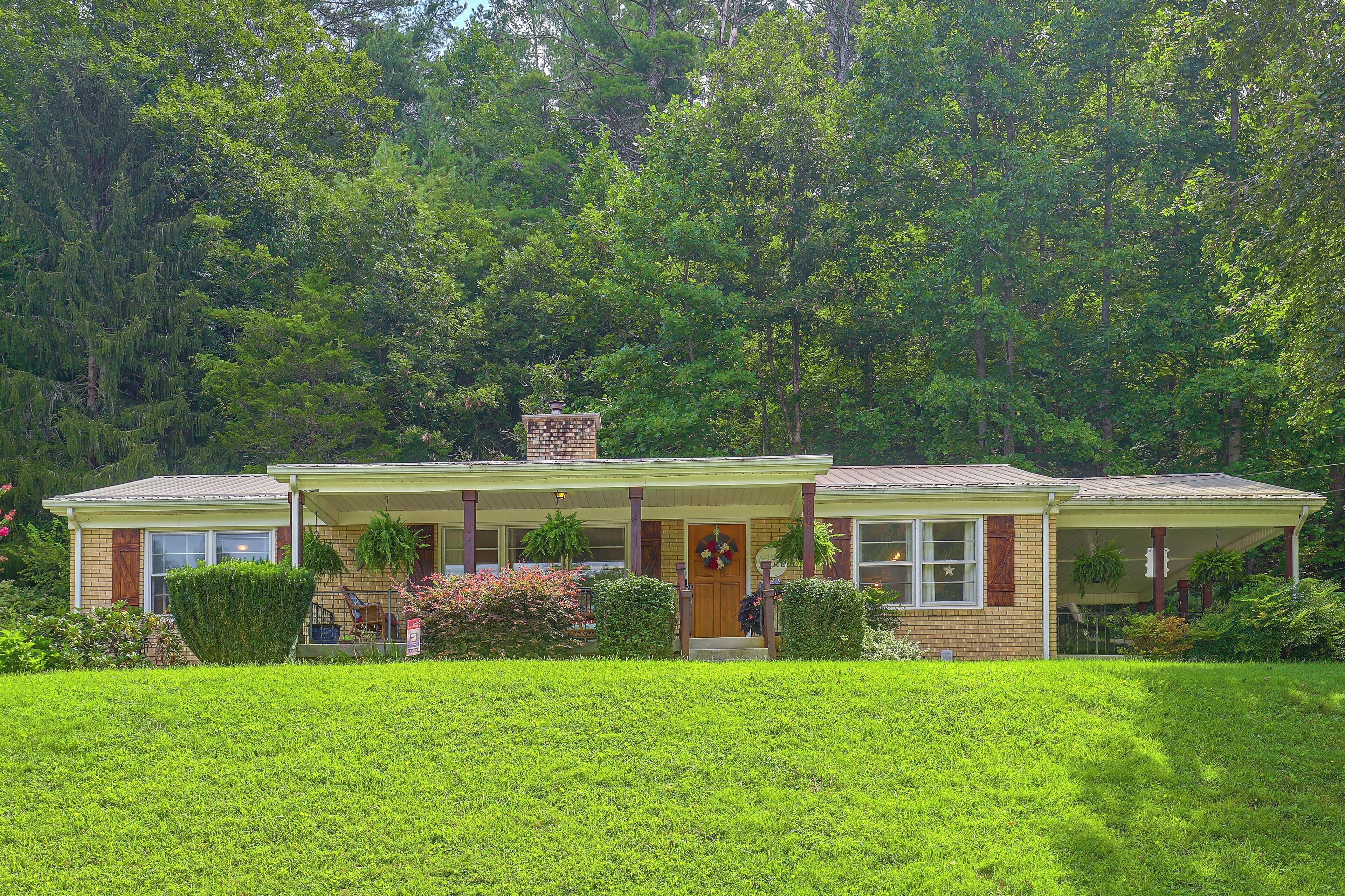 A two-story house with a front porch, a chimney, and a well-maintained lawn.