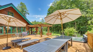 A wooden deck with outdoor furniture, including tables and chairs, and a hot tub. - Game Room w/ Speakeasy Saloon: Accord Retreat (Accord)
