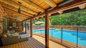 A wooden deck with a pool, outdoor furniture, and a view of the forest. - Game Room w/ Speakeasy Saloon: Accord Retreat (Accord)