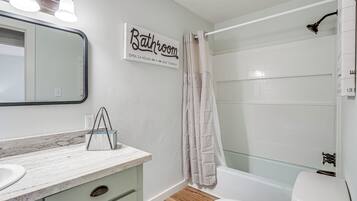 A bathroom with a white sink, mirror, and a sign that reads 'Bathroom Open 24 Hours Seat Yourself'.
