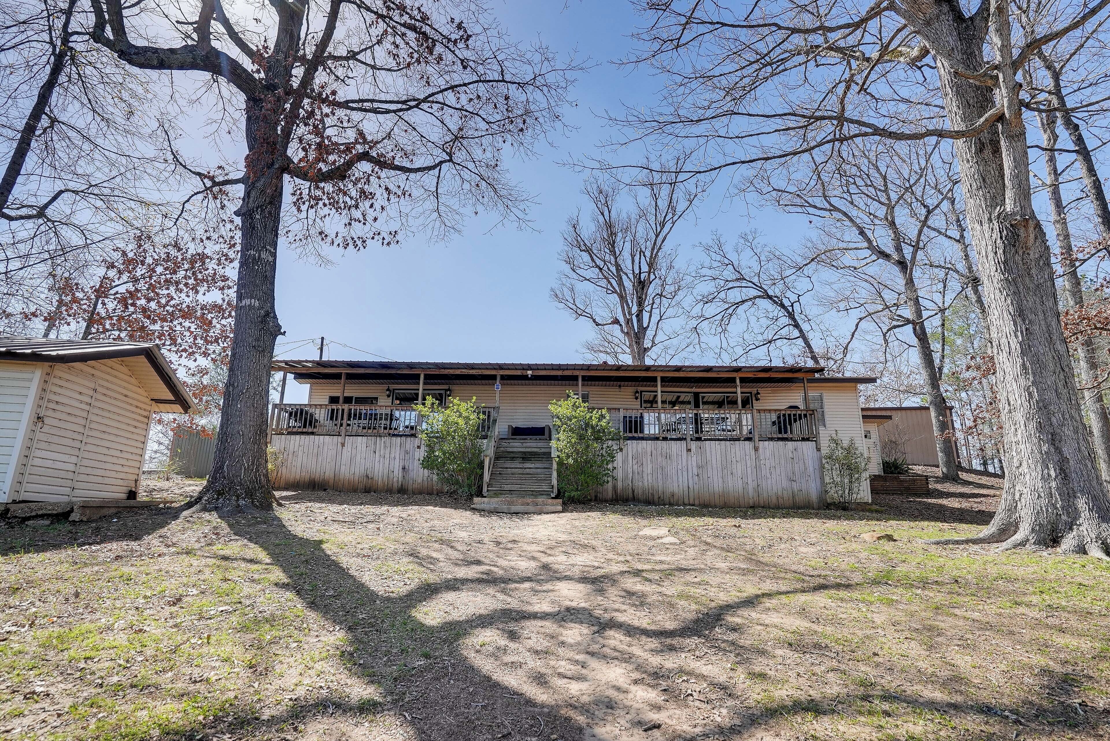 A single-story house with a front porch, a small front yard, and a wooden fence.