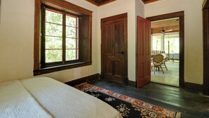 A room with a bed, a wooden door, and a window. - Island Cottage on Evans Lake: Boat Rental Required (Tipton)