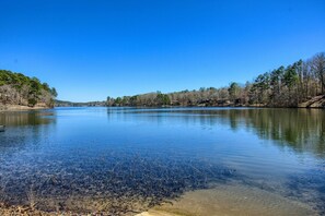 A calm lake with clear water, surrounded by trees and a distant shoreline. - Fire Pit & Grill: Tranquil Retreat in Hot Springs (Hot Springs Village)