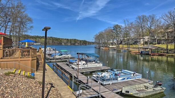 A dock with boats, a wooden deck, and a view of a lake. - Fire Pit & Grill: Tranquil Retreat in Hot Springs (Hot Springs Village)